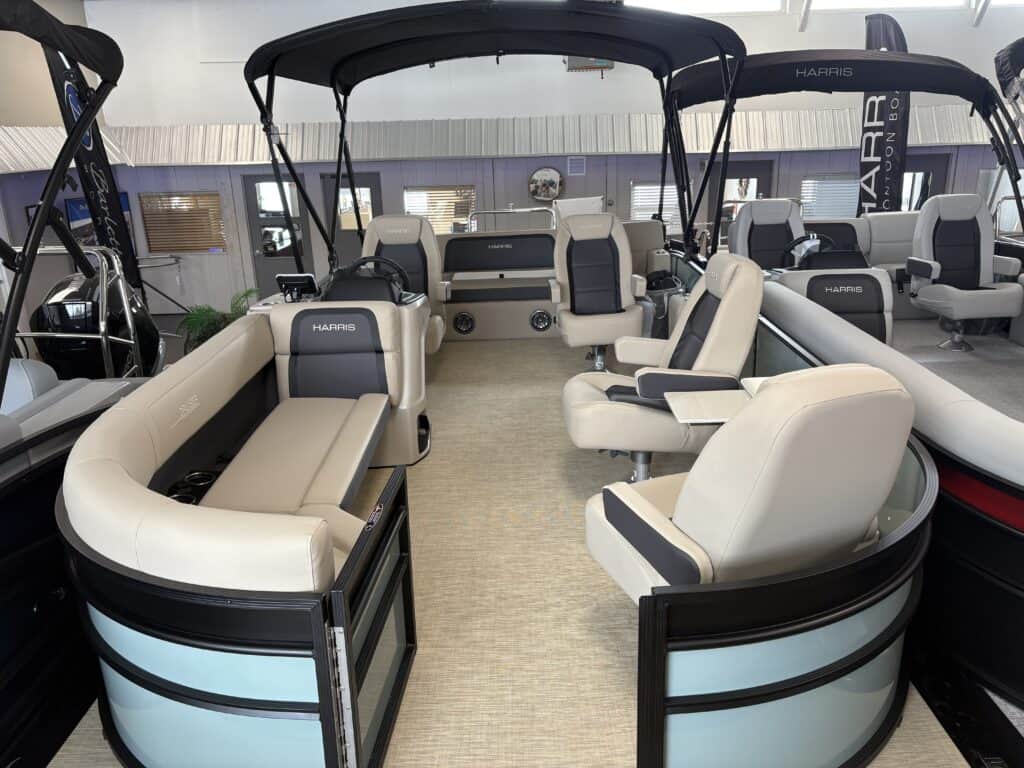 Interior view of a 2025 Harris Cruiser, featuring cushioned seating, a central aisle, and a black canopy overhead.